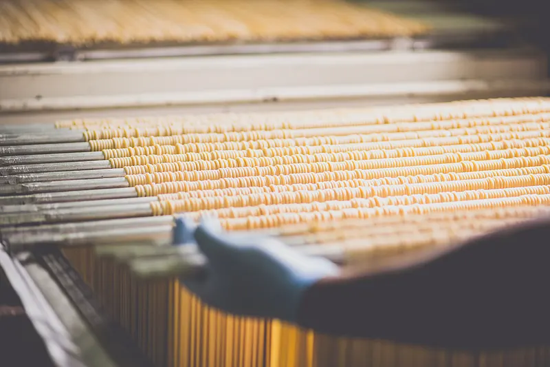 Fresh pasta on drying racks during an industrial food drying process.