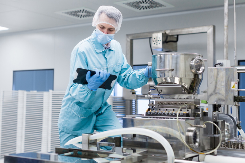 Environmental monitoring of a pharmaceutical plant by an employee in protective clothing