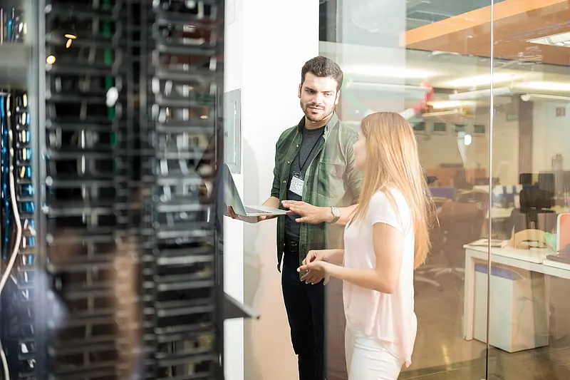 Data center energy efficiency measures: On-site analysis using precise measurement data Technician and engineer discussing data center energy efficiency measures outside the server room
